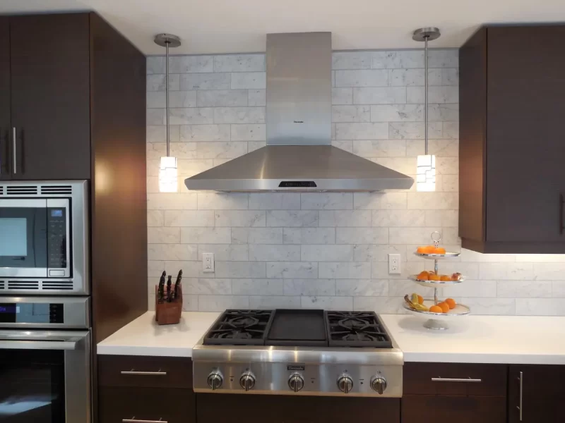 Gas Cooktop with stainless vent hood and tile surround