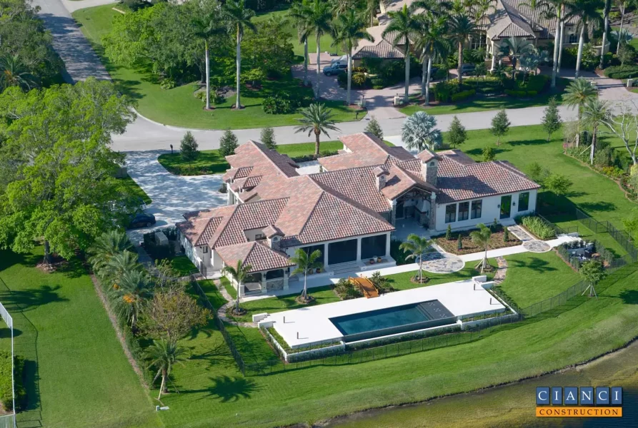 Tuscan Estate Home Construction aerial view looking from lakeside at pool area and back of home